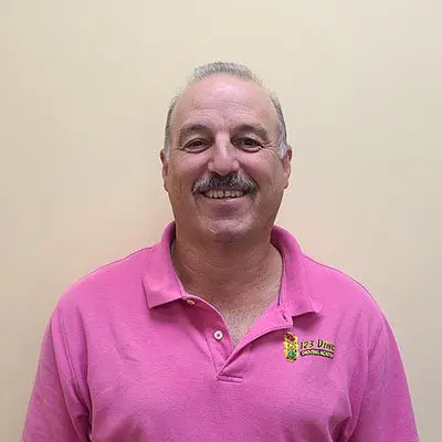 A man in pink shirt smiling for the camera.