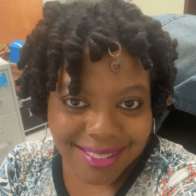 Smiling woman with chunky twists and heart charm